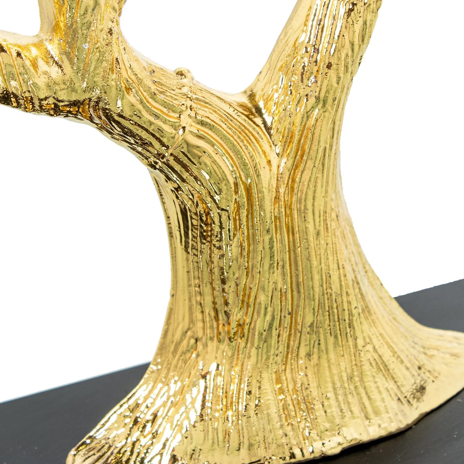 Scultura di albero della vita in metallo dorato, con tronco corposo e chioma ampia composta da rami intrecciati e foglie finemente dettagliate, poggiante su una base rettangolare in legno nero. Oggetto d'arredo scultoreo firmato E-Camacho, ideale come centrotavola o soprammobile elegante per la casa.
