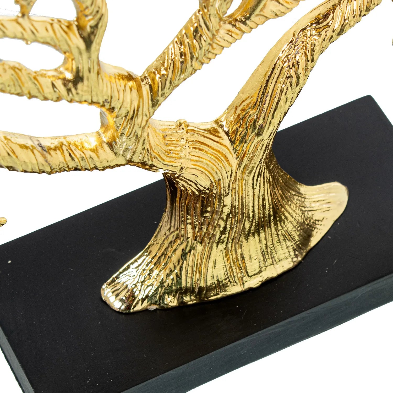Scultura di albero della vita in metallo dorato, con tronco corposo e chioma ampia composta da rami intrecciati e foglie finemente dettagliate, poggiante su una base rettangolare in legno nero. Oggetto d'arredo scultoreo firmato E-Camacho, ideale come centrotavola o soprammobile elegante per la casa.