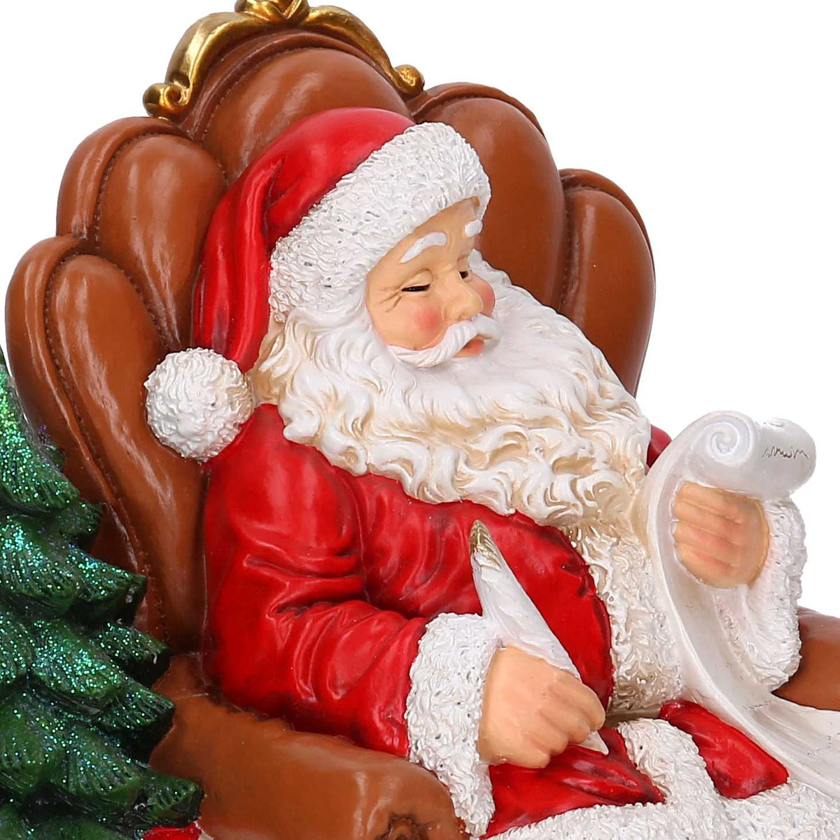 Statuina Vacchetti in resina di Babbo Natale seduto su poltrona mentre scrive la lista dei regali, con albero glitterato e pacchi colorati. Decorazione natalizia dipinta a mano, ideale per l’home décor e come idea regalo.