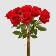 Mazzo di rose rosse artificiali dai petali vellutati con foglie verdi seghettate e legatura in rafia naturale. Composizione floreale artificiale, ideale per l’home décor e come idea regalo.