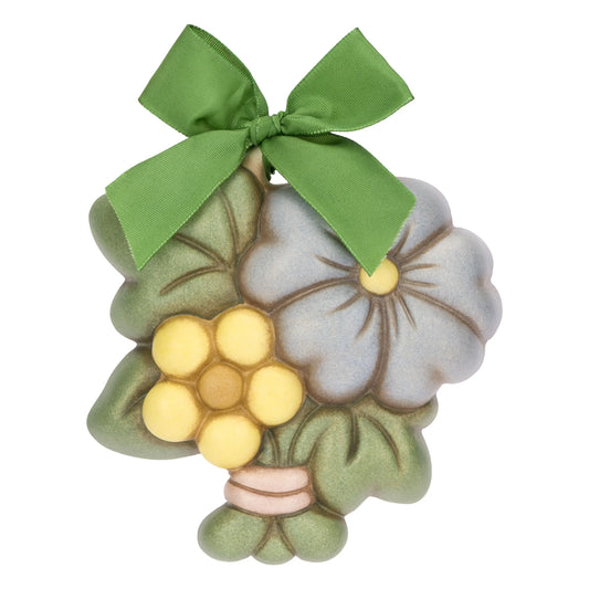 La Formella Piccola Fiore Malva THUN è un decoro da parete in ceramica dipinta a mano che raffigura un bouquet con fiori color malva e giallo arricchito da un elegante nastro verde a fiocco. Questo pezzo da collezione, mostrato nel file Formella Piccola Fiore Malva.png, rappresenta una perfetta idea regalo per decorare la casa con lo stile iconico e artigianale del marchio.