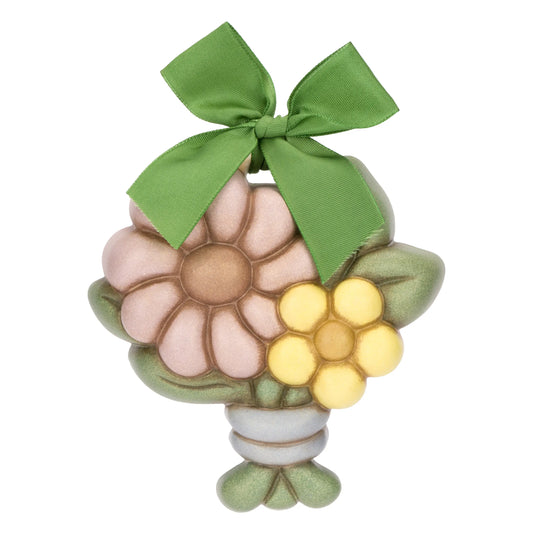 La Formella Piccola Fiore Calendula THUN è un decoro da parete in ceramica dipinta a mano che ritrae un bouquet floreale con petali rosa e gialli sormontato da un fiocco in nastro verde. Questo oggetto da collezione rappresenta una perfetta idea regalo per impreziosire gli ambienti domestici con l'inconfondibile stile artigianale del marchio.