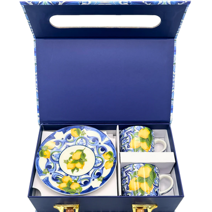 Vista interna del box regalo aperto con set di tazzine blu in ceramica. L'immagine mostra il packaging protettivo sagomato che valorizza il contrasto cromatico tra il blu della scatola e i decori vivaci delle tazzine.