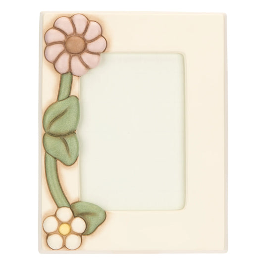 Il Portafoto Medio Calendula THUN è una cornice in ceramica decorata a mano impreziosita da un’applicazione floreale in rilievo con un grande fiore lilla e una margherita bianca lungo il bordo sinistro. Questo elegante complemento d'arredo rappresenta una perfetta idea regalo per conservare i ricordi più cari con l'inconfondibile stile artigianale del marchio.