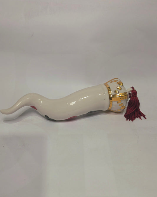 Corno portafortuna in ceramica bianca lucida decorato con i semi delle carte da gioco neri e rossi, completato da una corona regale bianca e oro con nappa coordinata. Questo raffinato oggetto scaramantico di design artigianale è un complemento d'arredo originale e scaramantico, perfetto come idea regalo o per decorare ambienti moderni con un tocco di tradizione napoletana.