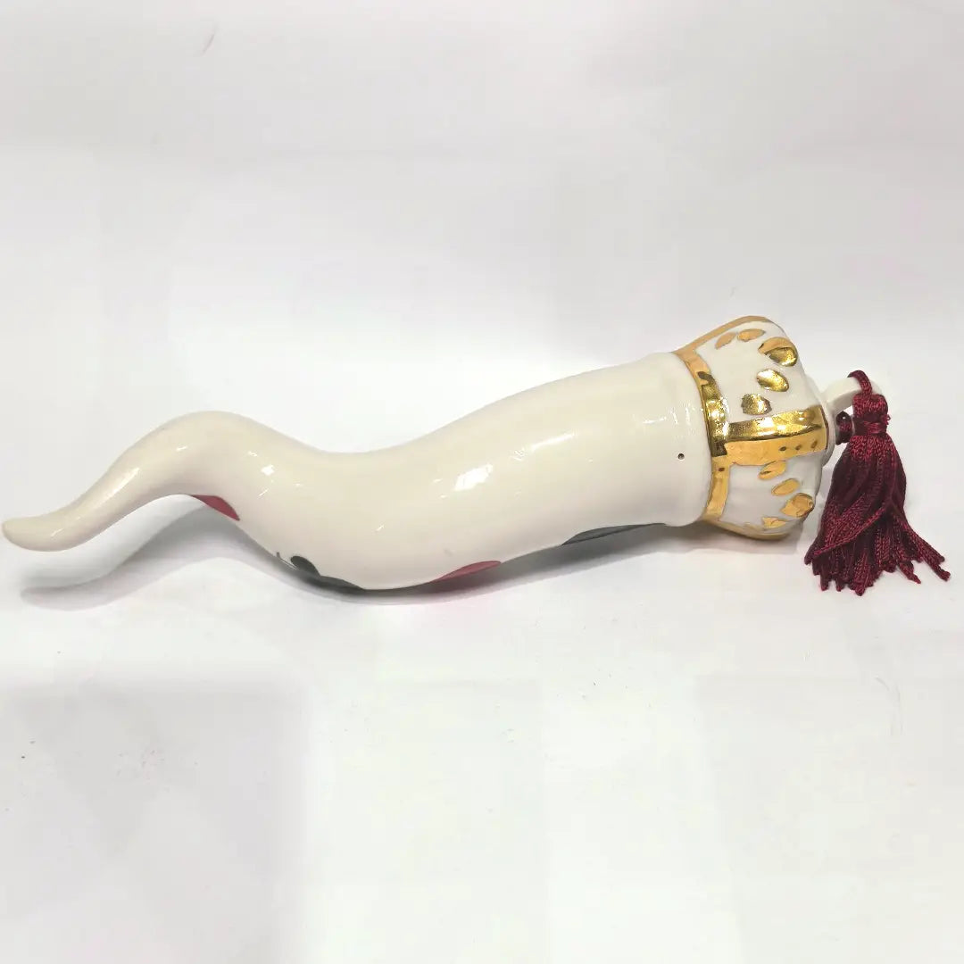 Corno portafortuna in ceramica bianca lucida decorato con i semi delle carte da gioco neri e rossi, completato da una corona regale bianca e oro con nappa coordinata. Questo raffinato oggetto scaramantico di design artigianale è un complemento d'arredo originale e scaramantico, perfetto come idea regalo o per decorare ambienti moderni con un tocco di tradizione napoletana.