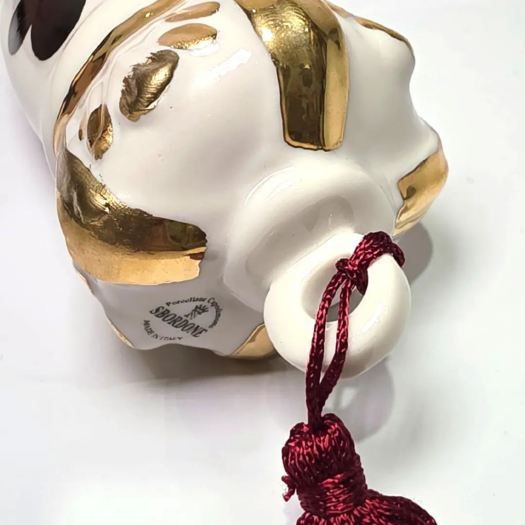 Corno portafortuna in ceramica bianca lucida decorato con i semi delle carte da gioco neri e rossi, completato da una corona regale bianca e oro con nappa coordinata. Questo raffinato oggetto scaramantico di design artigianale è un complemento d'arredo originale e scaramantico, perfetto come idea regalo o per decorare ambienti moderni con un tocco di tradizione napoletana.