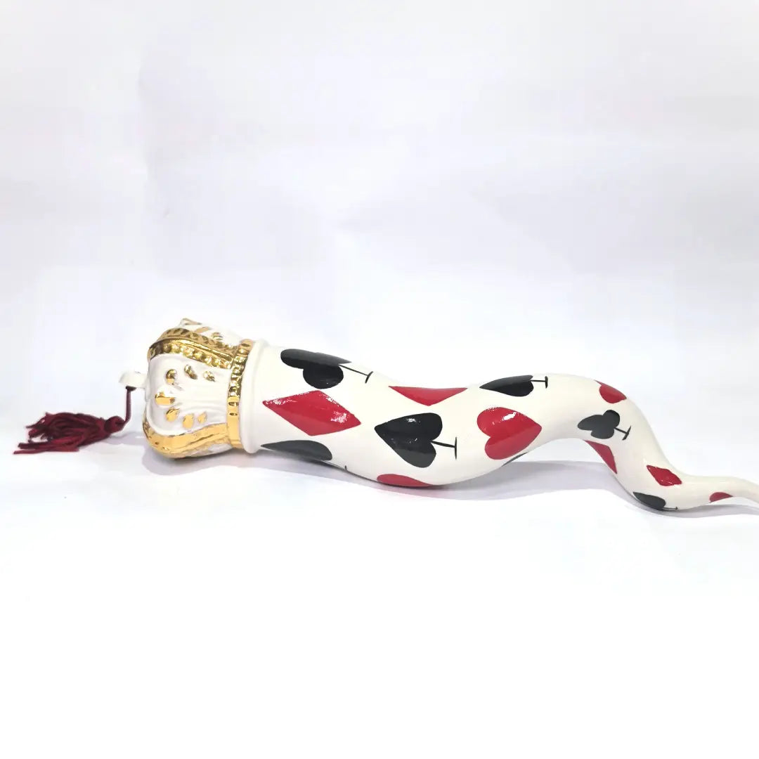 Corno portafortuna in ceramica bianca lucida decorato con i semi delle carte da gioco neri e rossi, completato da una corona regale bianca e oro con nappa coordinata. Questo raffinato oggetto scaramantico di design artigianale è un complemento d'arredo originale e scaramantico, perfetto come idea regalo o per decorare ambienti moderni con un tocco di tradizione napoletana.