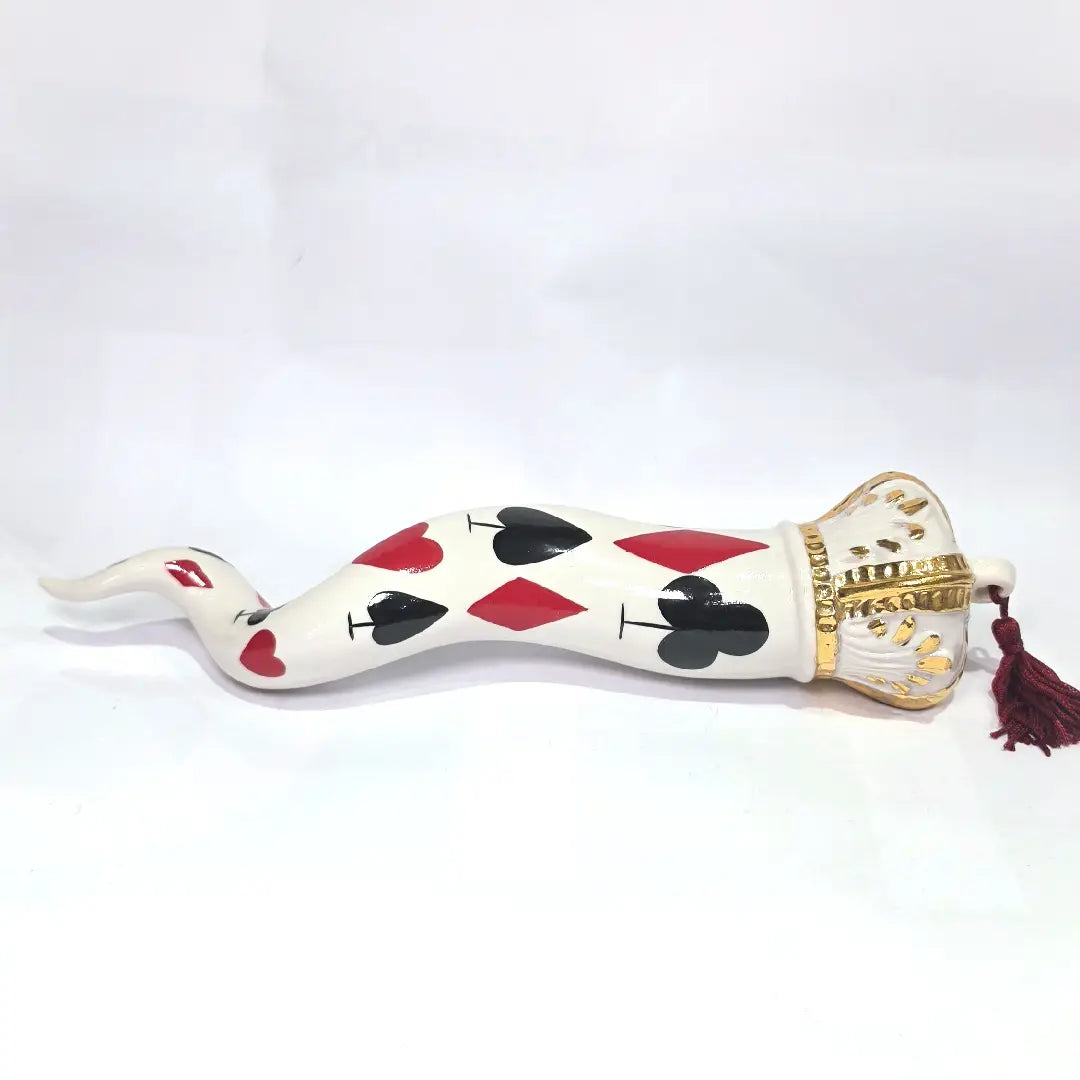 Corno portafortuna in ceramica bianca lucida decorato con i semi delle carte da gioco neri e rossi, completato da una corona regale bianca e oro con nappa coordinata. Questo raffinato oggetto scaramantico di design artigianale è un complemento d'arredo originale e scaramantico, perfetto come idea regalo o per decorare ambienti moderni con un tocco di tradizione napoletana.
