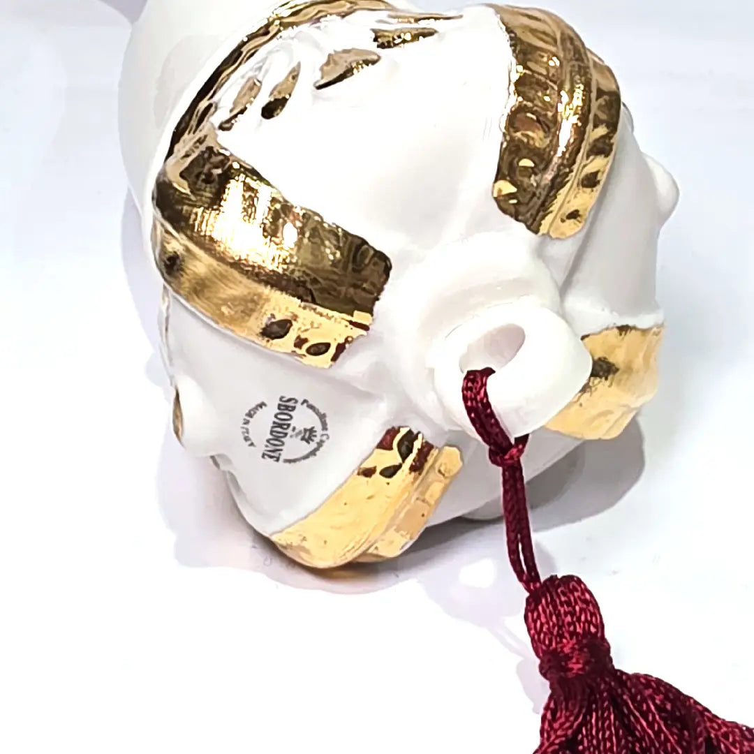 Corno portafortuna in ceramica bianca lucida decorato con i semi delle carte da gioco neri e rossi, completato da una corona regale bianca e oro con nappa coordinata. Questo raffinato oggetto scaramantico di design artigianale è un complemento d'arredo originale e scaramantico, perfetto come idea regalo o per decorare ambienti moderni con un tocco di tradizione napoletana.