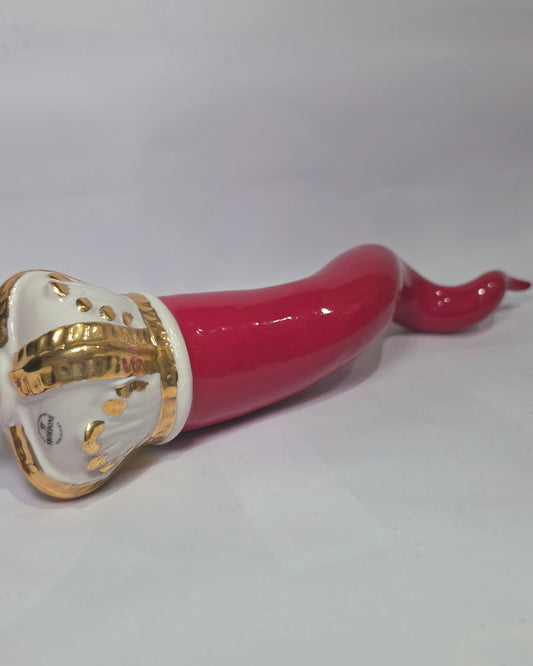 Corno portafortuna in ceramica rossa lucida caratterizzato da una corona regale bianca con decorazioni dorate e una nappa in tessuto rosso coordinata. Questo raffinato amuleto scaramantico dal design artigianale è un complemento d'arredo perfetto per decorare la casa con stile e tradizione.