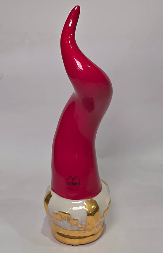 Corno portafortuna Regale in ceramica rossa lucida montato su una raffinata base d'appoggio bianca con eleganti venature e finiture dorate. Questo oggetto scaramantico di design artigianale, sormontato da una corona oro, rappresenta un complemento d'arredo esclusivo ideale per impreziosire interni moderni o classici.