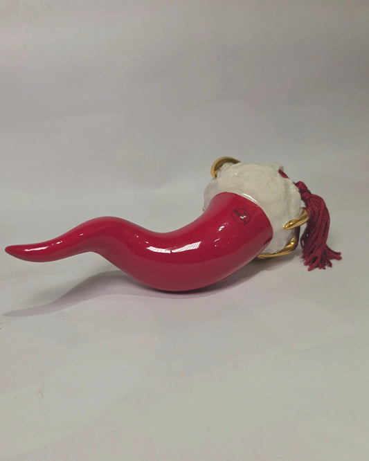 Corno portafortuna in ceramica rossa lucida di manifattura artigianale, caratterizzato da una punta ricurva e una corona regale dorata posta sulla sommità. Questo amuleto scaramantico dal design classico è un complemento d'arredo elegante, ideale come regalo di buon augurio o per decorare ambienti con un tocco di tradizione mediterranea.