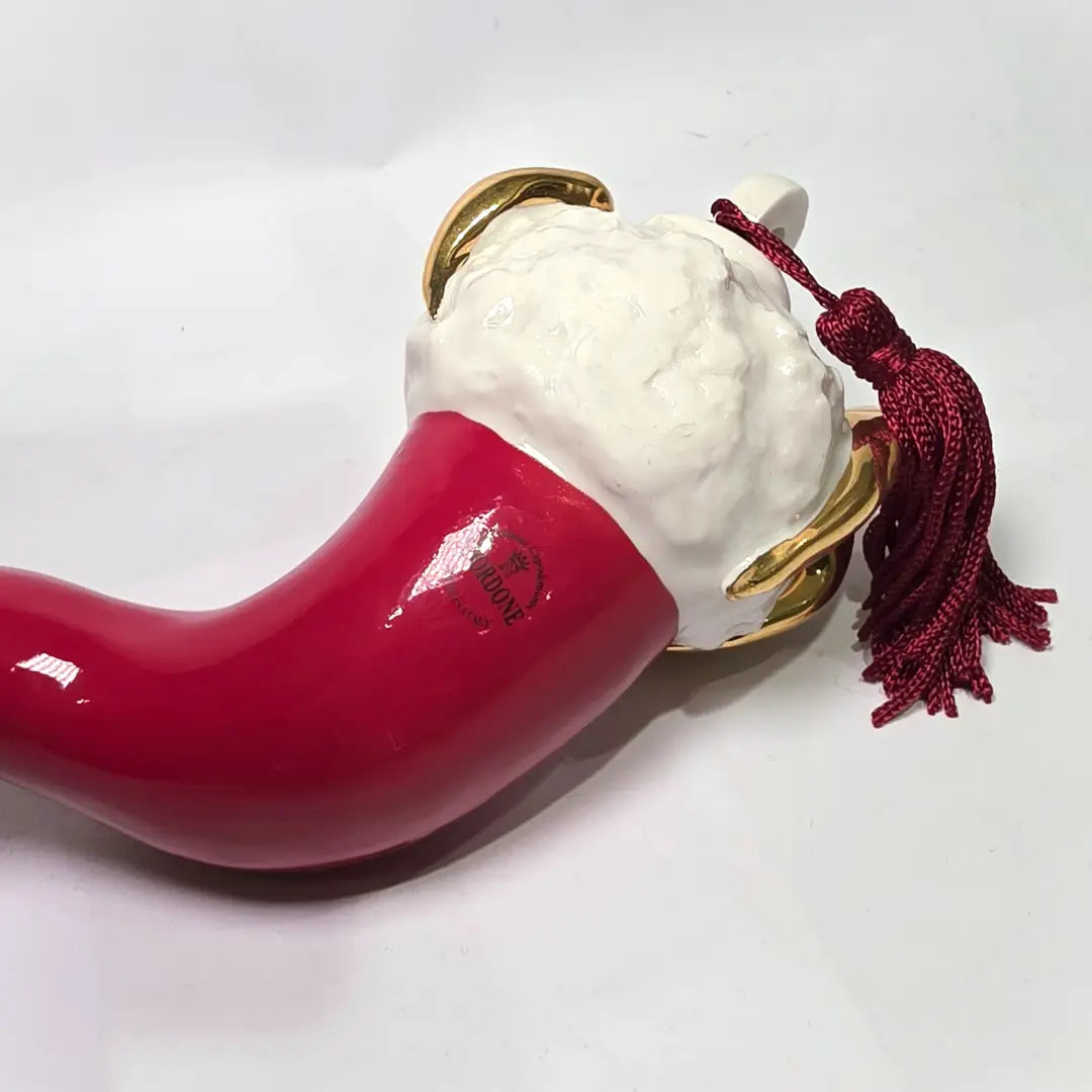 Corno portafortuna in ceramica rossa lucida di manifattura artigianale, caratterizzato da una punta ricurva e una corona regale dorata posta sulla sommità. Questo amuleto scaramantico dal design classico è un complemento d'arredo elegante, ideale come regalo di buon augurio o per decorare ambienti con un tocco di tradizione mediterranea.