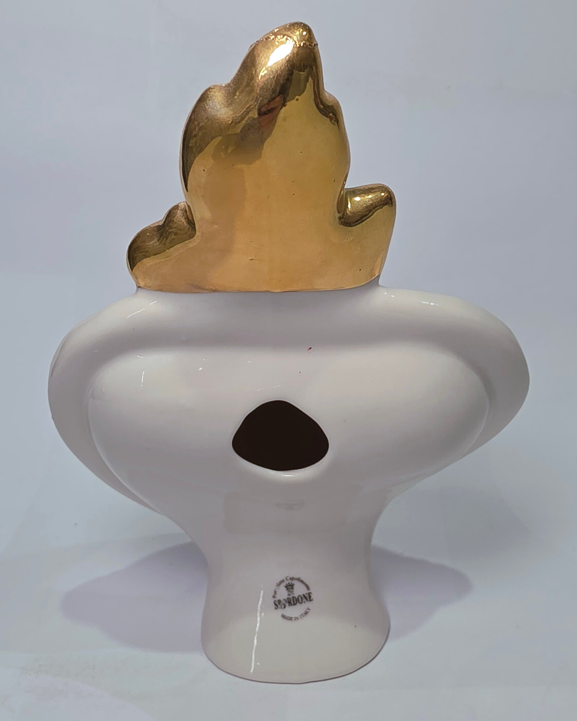 Scultura decorativa a forma di Cuore Sacro in ceramica bianca lucida, caratterizzata da un cuore rosso centrale sovrapposto a un disegno grafico nero che richiama il battito cardiaco. L'oggetto è impreziosito da una fiamma superiore dorata e una cornice perlinata con borchie oro, rendendolo un complemento d'arredo dal design moderno e originale.