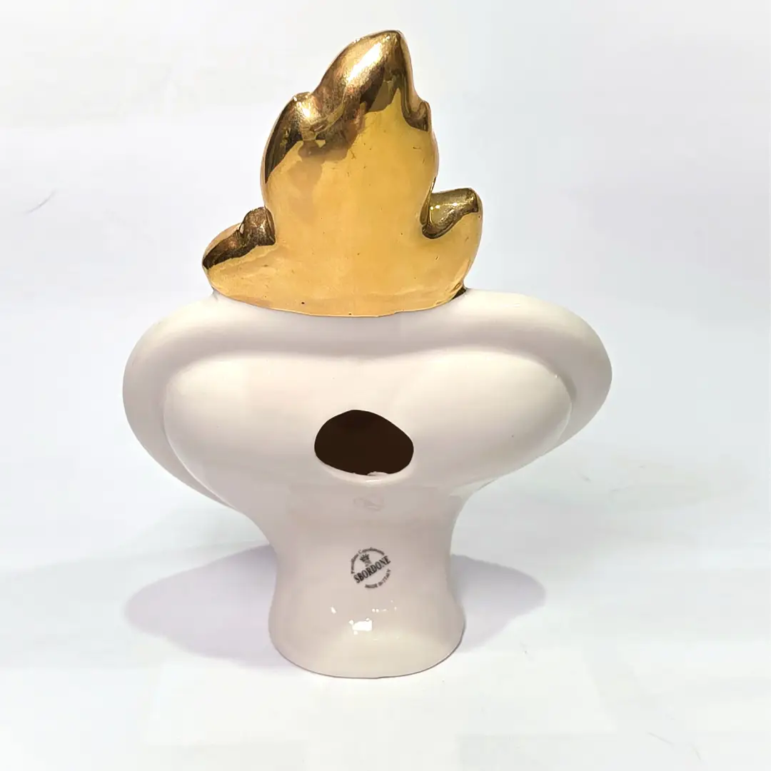 Scultura decorativa a forma di Cuore Sacro in ceramica bianca lucida, decorata al centro con un cuore rosso e una pergamena con la scritta "Ti Amo". L'oggetto è impreziosito da una fiamma superiore dorata e una cornice perlinata con borchie oro, rappresentando un'idea regalo romantica e un complemento d'arredo dal design unico.