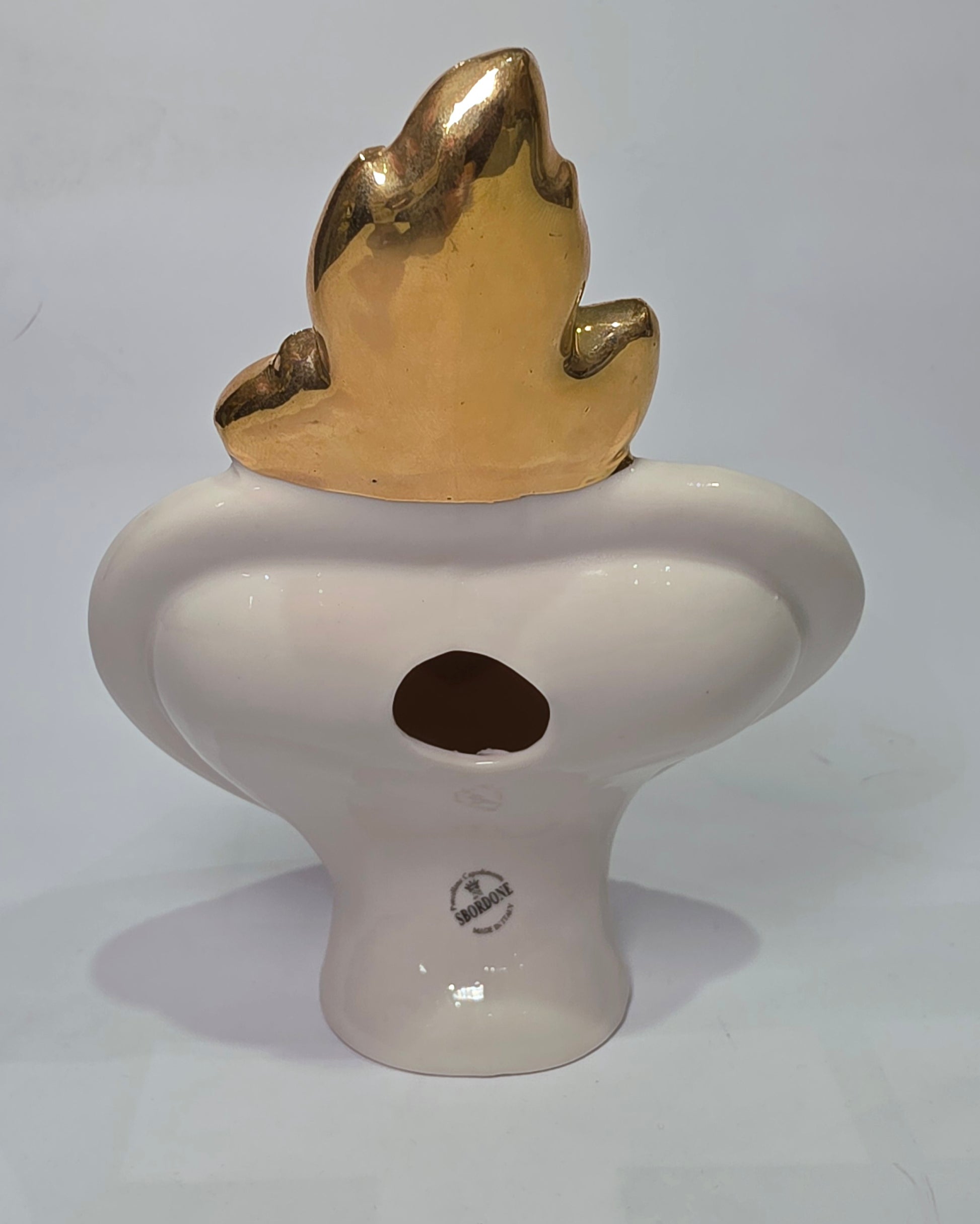 Scultura decorativa a forma di Cuore Sacro in ceramica bianca lucida, decorata al centro con un cuore rosso e una pergamena con la scritta "Ti Amo". L'oggetto è impreziosito da una fiamma superiore dorata e una cornice perlinata con borchie oro, rappresentando un'idea regalo romantica e un complemento d'arredo dal design unico.