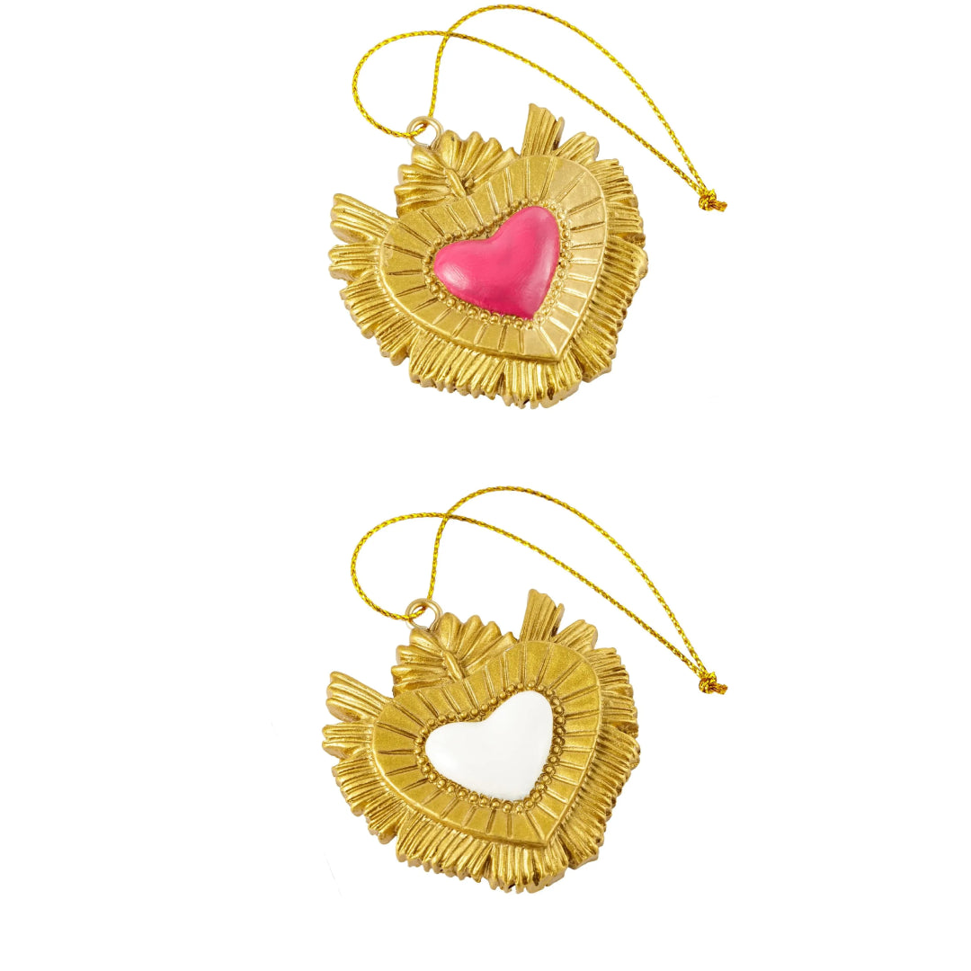 Ciondolo decorativo a forma di cuore sacro votivo, con cornice dorata a motivi barocchi e fiamma superiore, centro smaltato fucsia o bianco e nastro dorato per appenderlo, misure 5x5 cm. Decoro portafortuna artigianale firmato Montemaggi, ideale come ornamento per l'albero o idea regalo originale.