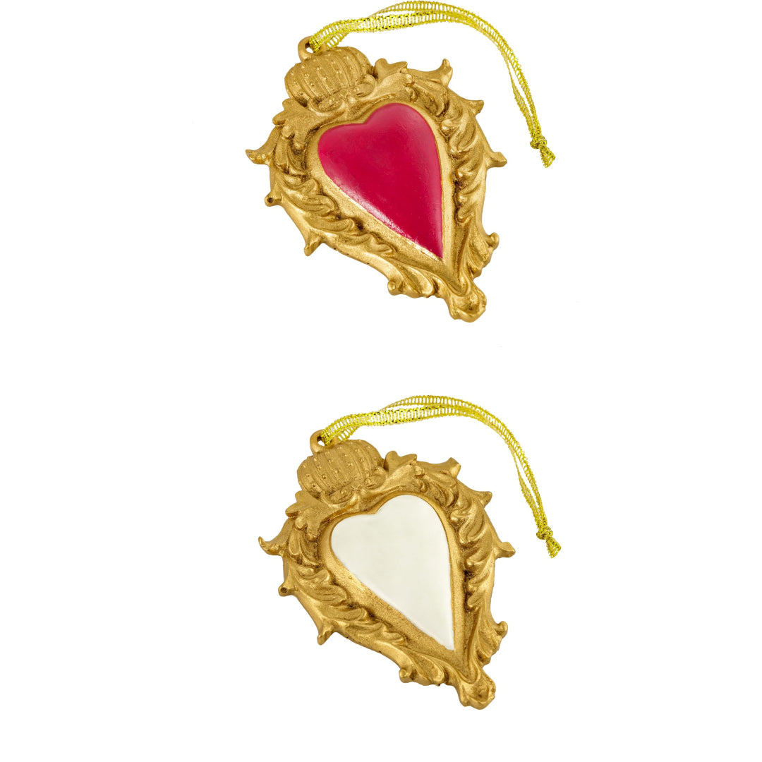 Ciondolo decorativo a forma di cuore sacro votivo, con cornice dorata a motivi barocchi e fiamma superiore, centro smaltato fucsia o bianco e nastro dorato per appenderlo, misure 10x7 cm. Decoro portafortuna artigianale firmato Montemaggi, ideale come ornamento per l'albero o idea regalo originale.