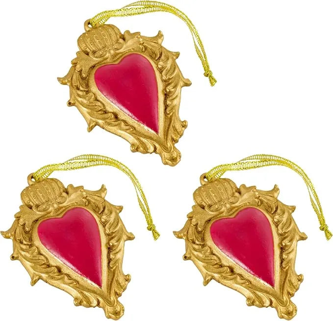 Ciondolo decorativo a forma di cuore sacro votivo, con cornice dorata a motivi barocchi e fiamma superiore, centro smaltato fucsia e nastro dorato per appenderlo, misure 10x7 cm. Decoro portafortuna artigianale firmato Montemaggi, ideale come ornamento per l'albero o idea regalo originale.