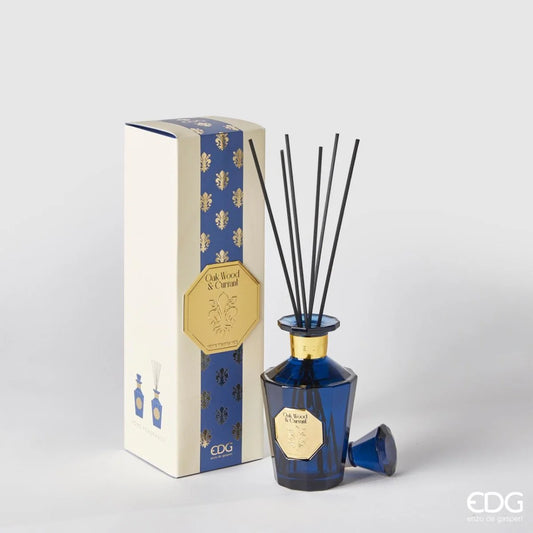 Il Diffusore per Ambienti Goldlily Oak Wood e Blackcurrant EDG è un set di lusso composto da una raffinata bottiglia in vetro sfaccettato blu cobalto con dettagli dorati e bastoncini neri. La confezione coordinata presenta eleganti decorazioni a giglio oro su fondo blu, rendendo questa intensa fragranza fruttata e legnosa un esclusivo elemento di design per profumare la casa con stile.