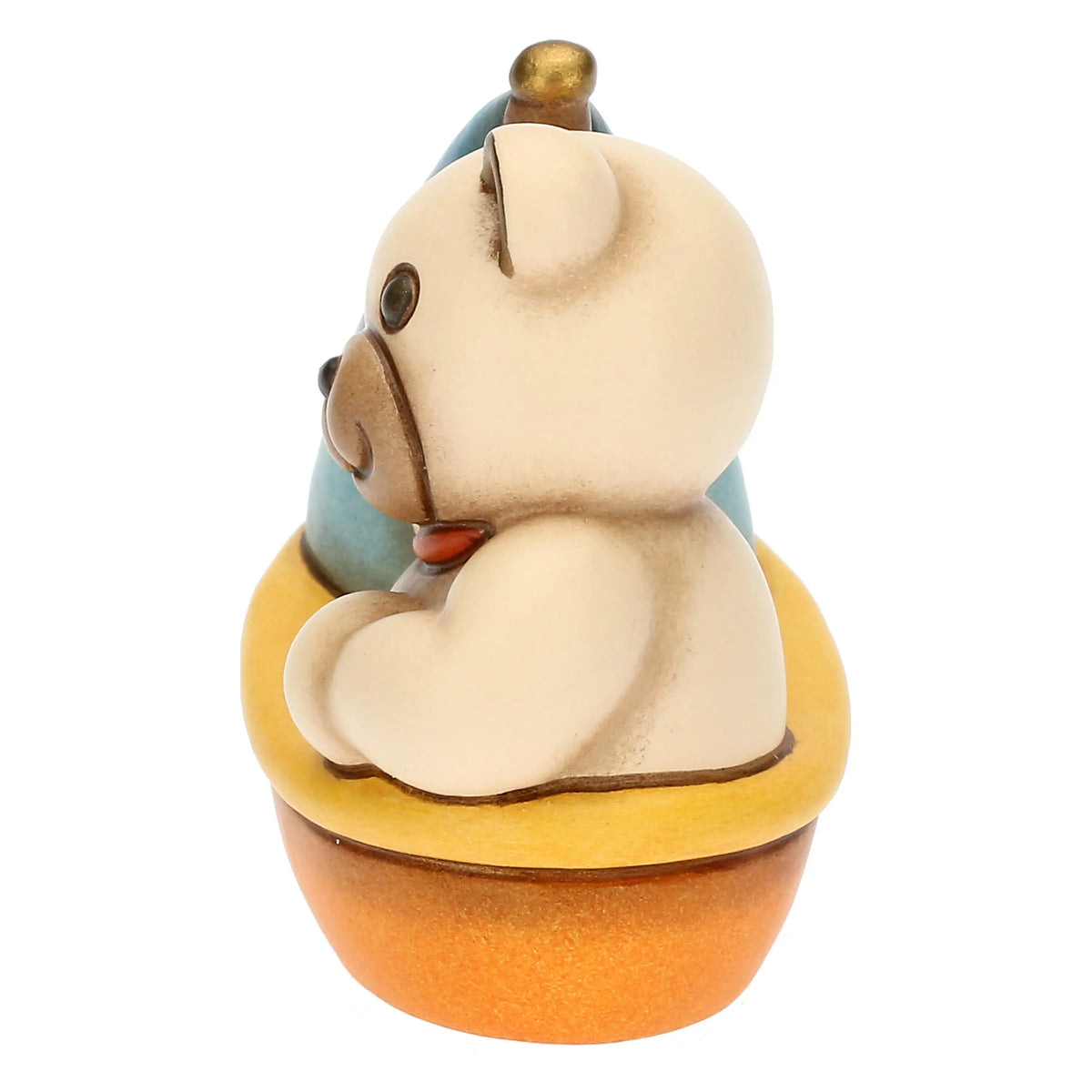 Statuina in ceramica raffigurante un orsetto teddy seduto su una barchetta azzurra, gialla e arancio con vela blu e camino dorato. Decorazione dipinta a mano, ideale per la cameretta e come idea regalo.