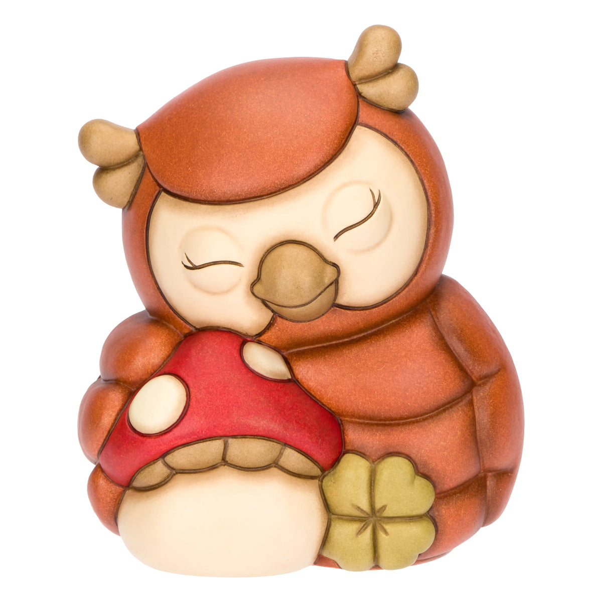 La statuetta Gufo con Fungo THUN è un soprammobile in ceramica decorata a mano che ritrae un tenero gufetto addormentato mentre abbraccia un fungo rosso e un quadrifoglio portafortuna. Questa creazione artigianale dai toni caldi del marrone è un complemento d'arredo perfetto per decorare la casa o come preziosa idea regalo da collezione.