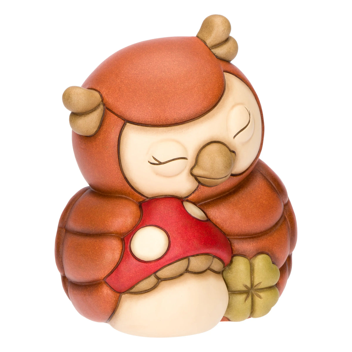 La statuetta Gufo con Fungo THUN è un soprammobile in ceramica decorata a mano che ritrae un tenero gufetto addormentato mentre abbraccia un fungo rosso e un quadrifoglio portafortuna. Questa creazione artigianale dai toni caldi del marrone è un complemento d'arredo perfetto per decorare la casa o come preziosa idea regalo da collezione.