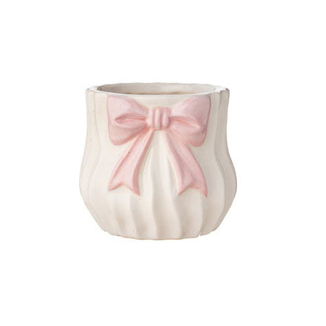 Vaso basso in ceramica bianca del marchio L'arte dei nacchi con design bombato e superficie decorata da scanalature verticali a effetto plissettato. Il prodotto presenta un elegante fiocco rosa applicato in rilievo sul fronte, caratterizzato da code lunghe e una finitura opaca, ideale come portaoggetti, piccolo vaso o bomboniera raffinata per eventi e decorazione d'interni.