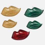 Vassoio svuotatasche a forma di bocca firmato Ilary Queen, caratterizzato da un design a labbra sagomate con una suggestiva superficie texturizzata dall'effetto glitterato e metallico. Disponibile in diverse varianti di colore assortite tra cui oro scintillante, verde smeraldo e rosso rubino, questo elegante e moderno oggetto decorativo è perfetto come svuotatasche da ingresso o come originale idea regalo per la casa.