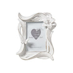 
Cornice portafoto del marchio L'arte dei nacchi realizzata in resina bianca con una particolare lavorazione dinamica a onde ed effetto decapato tipico dello stile shabby chic. Il design è impreziosito da un fiore tridimensionale in rilievo posizionato sull'angolo superiore destro e da una piccola farfalla coordinata applicata sul lato sinistro della cornice. Questo portafoto decorativo è ideale per personalizzare l'arredamento di camere e soggiorni o come bomboniera ricercata per cerimonie e ricorrenze spe