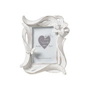 
Cornice portafoto del marchio L'arte dei nacchi realizzata in resina bianca con una particolare lavorazione dinamica a onde ed effetto decapato tipico dello stile shabby chic. Il design è impreziosito da un fiore tridimensionale in rilievo posizionato sull'angolo superiore destro e da una piccola farfalla coordinata applicata sul lato sinistro della cornice. Questo portafoto decorativo è ideale per personalizzare l'arredamento di camere e soggiorni o come bomboniera ricercata per cerimonie e ricorrenze spe