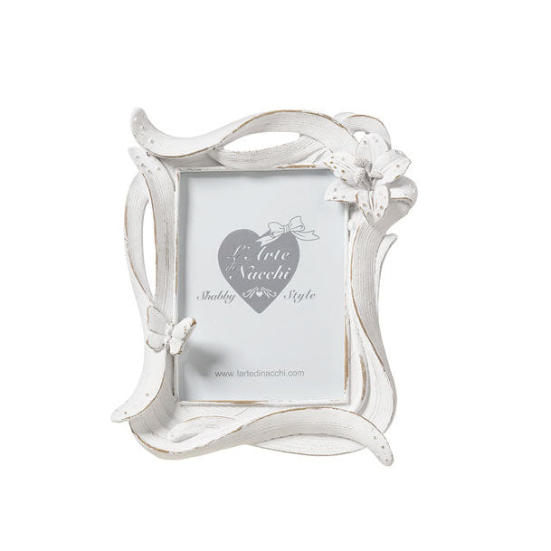 
Cornice portafoto del marchio L'arte dei nacchi realizzata in resina bianca con una particolare lavorazione dinamica a onde ed effetto decapato tipico dello stile shabby chic. Il design è impreziosito da un fiore tridimensionale in rilievo posizionato sull'angolo superiore destro e da una piccola farfalla coordinata applicata sul lato sinistro della cornice. Questo portafoto decorativo è ideale per personalizzare l'arredamento di camere e soggiorni o come bomboniera ricercata per cerimonie e ricorrenze spe