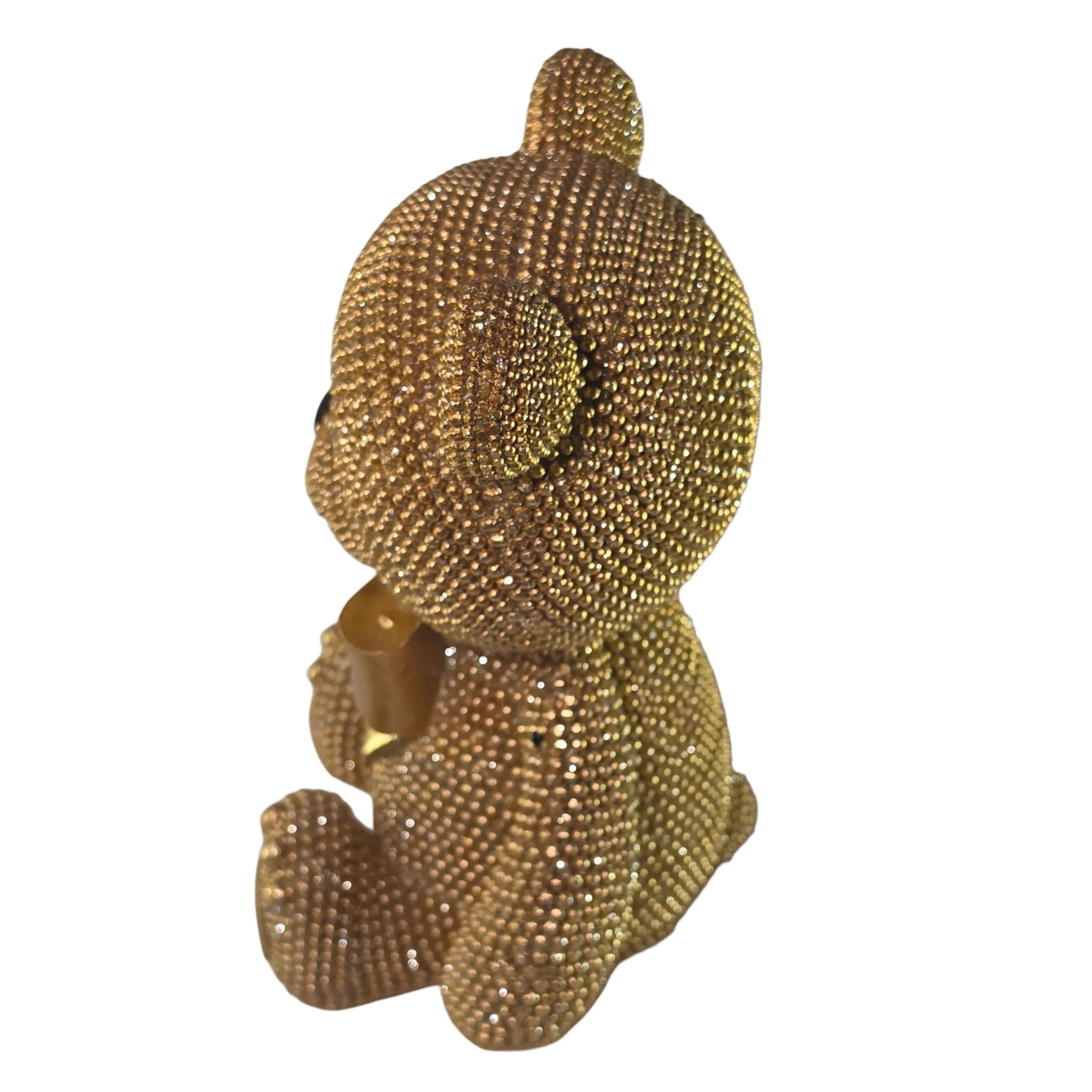 Statuina orsetto in resina dorata interamente ricoperta di brillantini glitterati, con fiocco raso oro al collo, occhi e naso neri e cuciture in rilievo sulle zampe. Oggetto decorativo scintillante firmato Sud Import, ideale come soprammobile glamour o idea regalo per bambini e occasioni speciali.