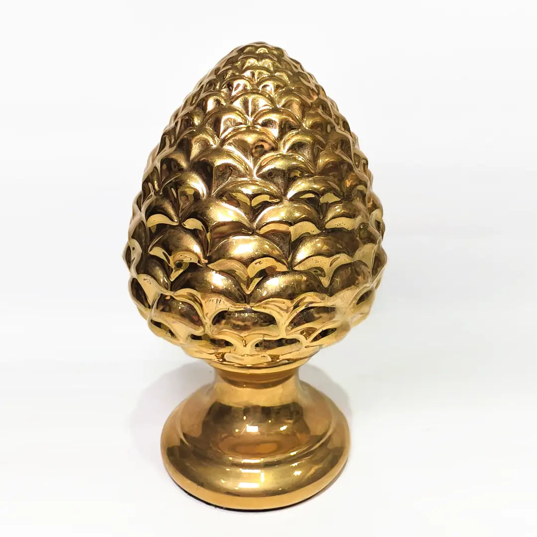 Pigna portafortuna in ceramica dorata lucida di manifattura artigianale, caratterizzata da squame finemente modellate e una solida base d'appoggio coordinata. Questo raffinato oggetto ornamentale rappresenta un simbolo di prosperità e accoglienza, perfetto come complemento d'arredo di lusso per interni classici o moderni.