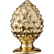 Pigna decorativa in ceramica dorata dalla tipica forma siciliana, con superficie lucida a squame in rilievo e base tornita. Oggetto d'arredo dalla tradizione mediterranea firmato Montemaggi, ideale come soprammobile o idea regalo raffinata.