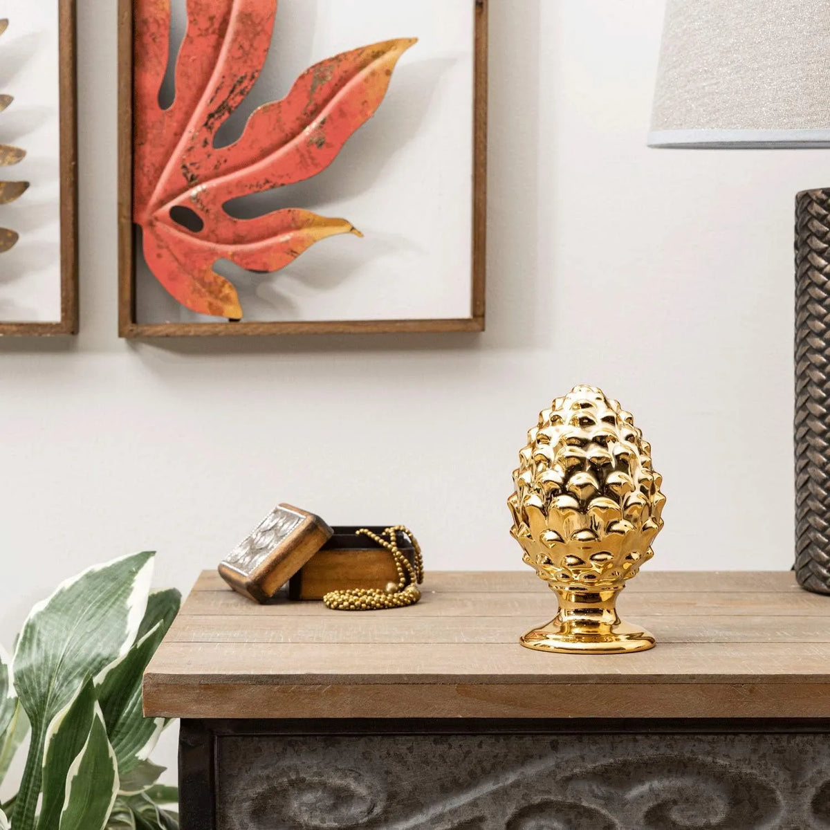 Pigna decorativa in ceramica dorata dalla tipica forma siciliana, con superficie lucida a squame in rilievo e base tornita. Oggetto d'arredo dalla tradizione mediterranea firmato Montemaggi, ideale come soprammobile o idea regalo raffinata.