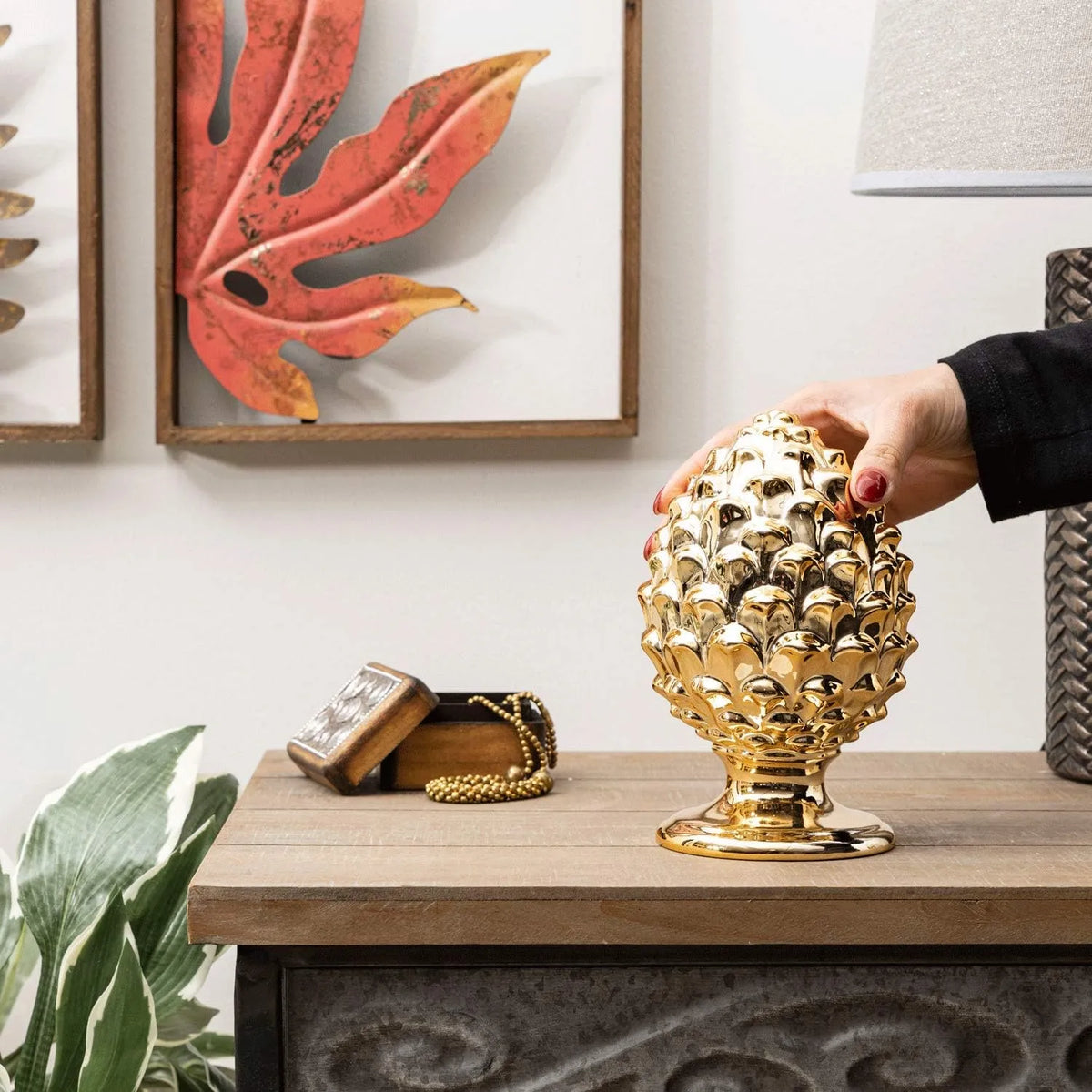 Pigna decorativa in ceramica dorata dalla tipica forma siciliana, con superficie lucida a squame in rilievo e base tornita. Oggetto d'arredo dalla tradizione mediterranea firmato Montemaggi, ideale come soprammobile o idea regalo raffinata.