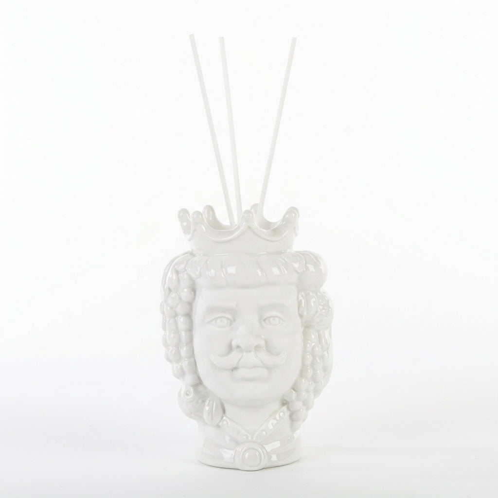 Profumatore d'ambiente in ceramica bianca lucida raffigurante una testa di moro maschile con corona e baffi, decorata con grappoli d'uva e foglie in rilievo, con bastoncini bianchi e boccetta di fragranza "Home Fragrance". Diffusore dalla tradizione siciliana firmato Le Stelle, presentato con la sua confezione bianca del marchio, ideale come idea regalo raffinata.