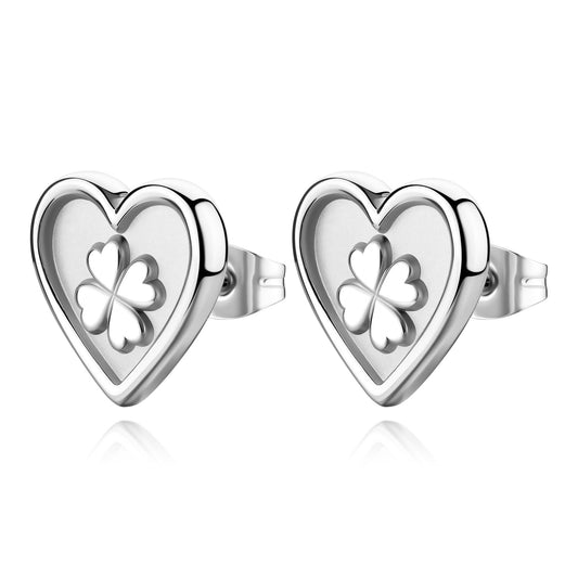 Orecchini a lobo S'agapò della collezione Duh Duh realizzati in acciaio anallergico con un design a forma di cuore dalla finitura lucida. Al centro di ogni cuore è presente un inserto satinato con un quadrifoglio portafortuna in rilievo finemente dettagliata. Gli orecchini sono dotati di una pratica chiusura a farfalla posteriore che garantisce una tenuta sicura e confortevole.
