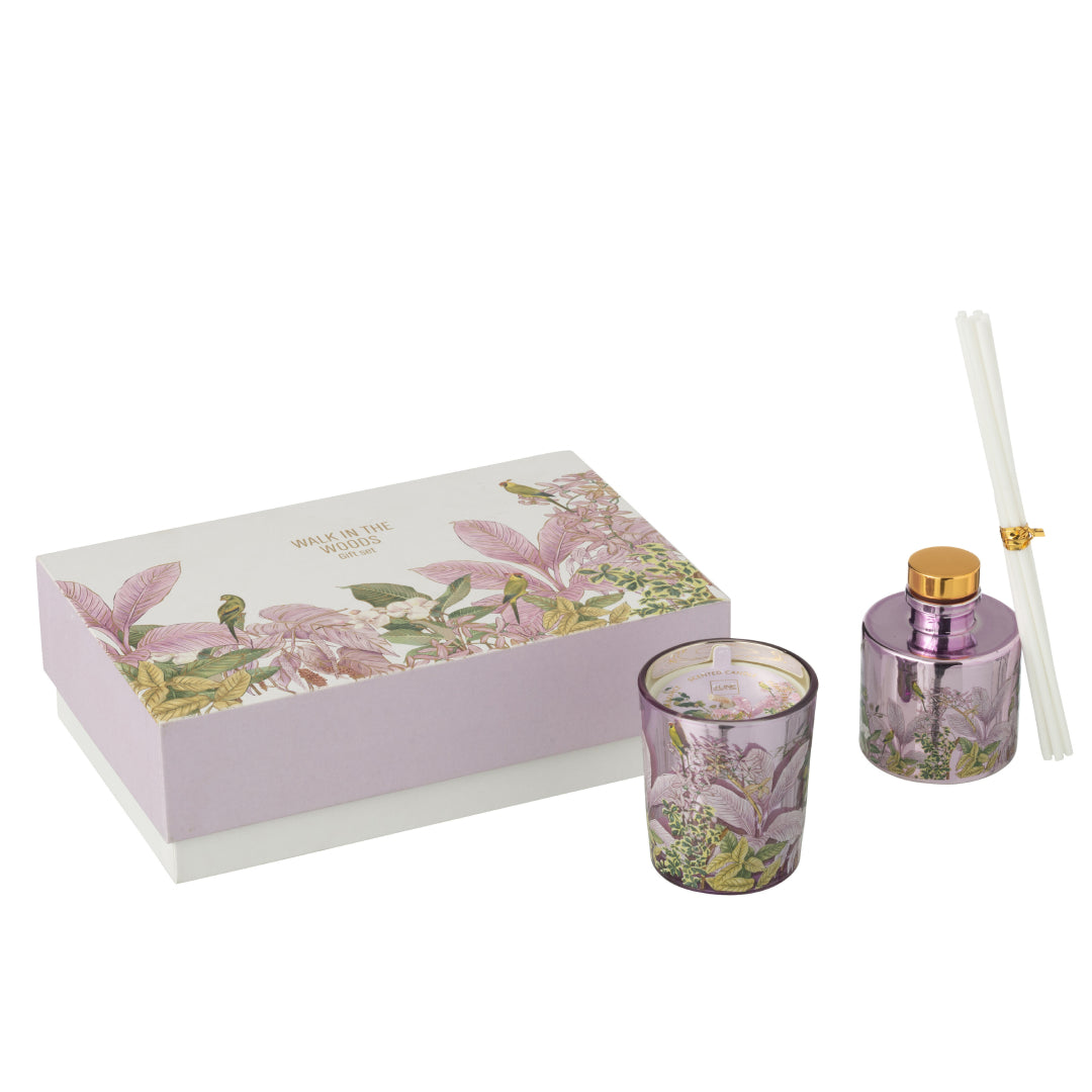 Il Set Regalo Candela e Diffusore Walk in the Woods Jolipa è un elegante cofanetto benessere che include una candela profumata e un diffusore di fragranza in vasi di vetro lilla con decorazioni botaniche. La confezione regalo raffinata con motivi di uccellini e foglie tropicali rosa rende questo kit perfetto per profumare la casa con stile o come pensiero speciale per l'home decor.