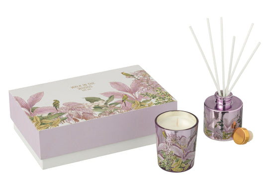 Il Set Regalo Candela e Diffusore Walk in the Woods Jolipa è un elegante cofanetto benessere che include una candela profumata e un diffusore di fragranza in vasi di vetro lilla con decorazioni botaniche. La confezione regalo raffinata con motivi di uccellini e foglie tropicali rosa rende questo kit perfetto per profumare la casa con stile o come pensiero speciale per l'home decor.