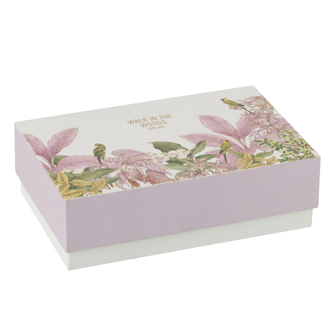 Il Set Regalo Candela e Diffusore Walk in the Woods Jolipa è un elegante cofanetto benessere che include una candela profumata e un diffusore di fragranza in vasi di vetro lilla con decorazioni botaniche. La confezione regalo raffinata con motivi di uccellini e foglie tropicali rosa rende questo kit perfetto per profumare la casa con stile o come pensiero speciale per l'home decor.