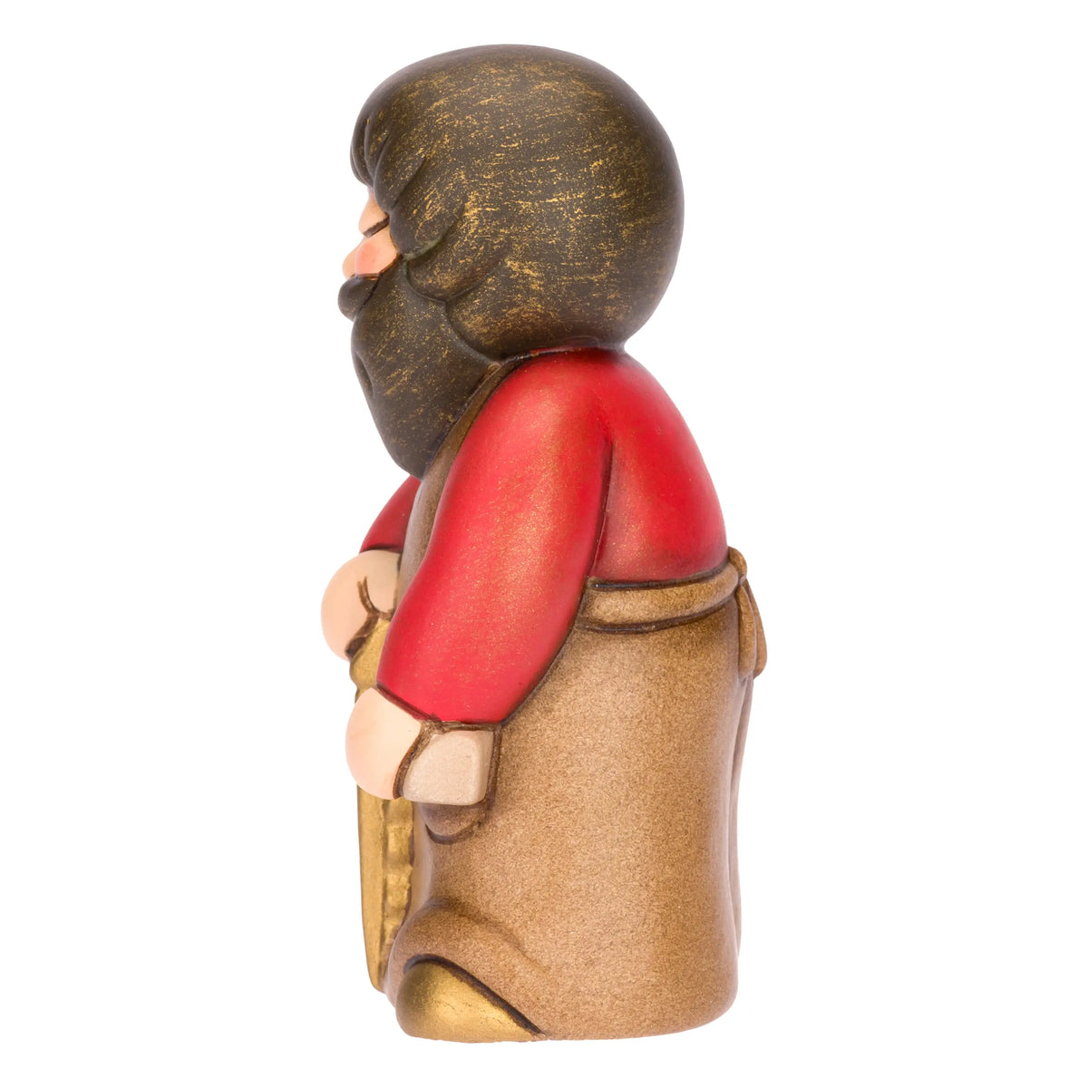 Statuina in ceramica raffigurante un falegname del presepe con folta barba e maglione rosso sotto il grembiule marrone, intento a segare un tronco di legno con una sega dorata. Personaggio dal design classico e curato firmato THUN, ideale per arricchire il presepe o come idea regalo natalizia.