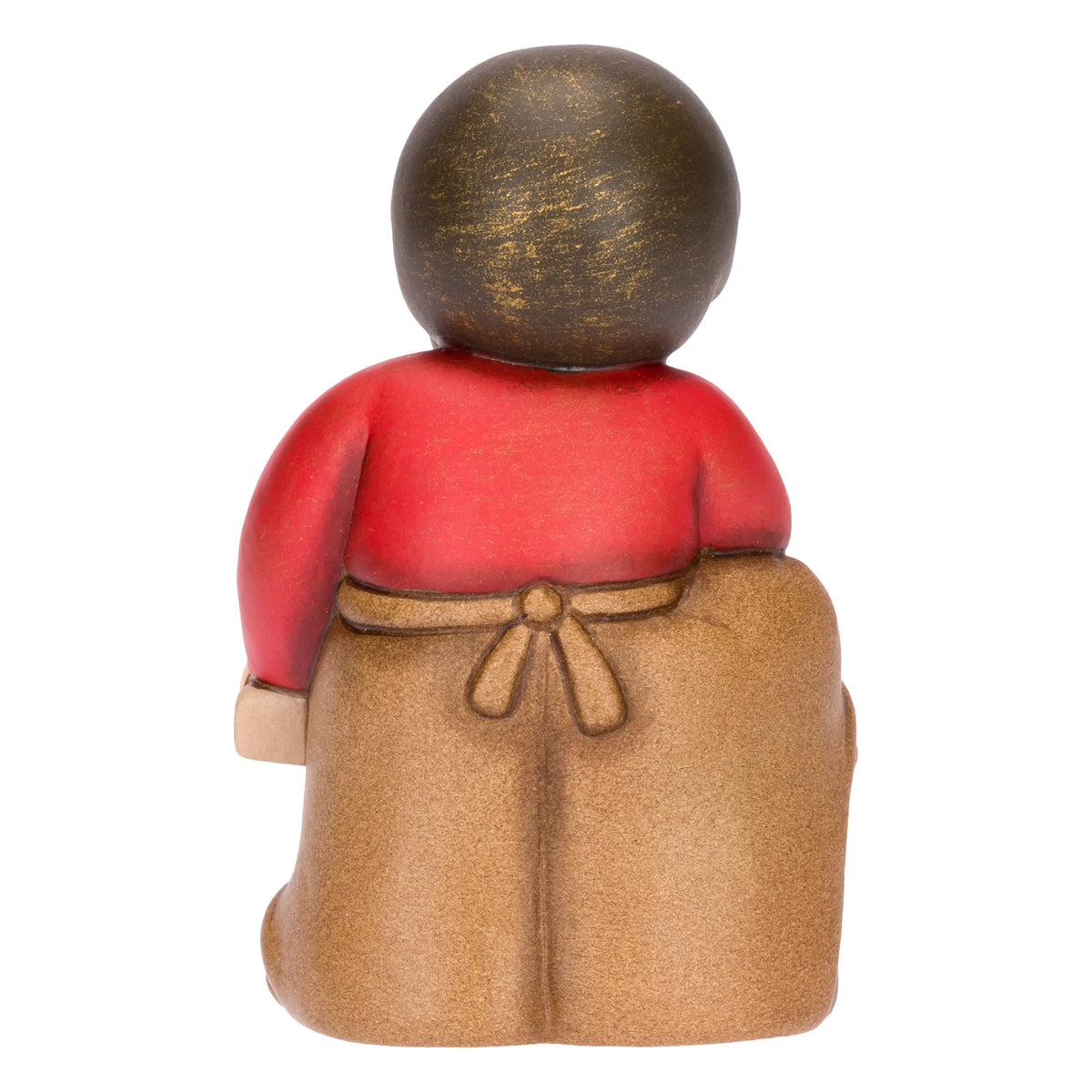 Statuina in ceramica raffigurante un falegname del presepe con folta barba e maglione rosso sotto il grembiule marrone, intento a segare un tronco di legno con una sega dorata. Personaggio dal design classico e curato firmato THUN, ideale per arricchire il presepe o come idea regalo natalizia.