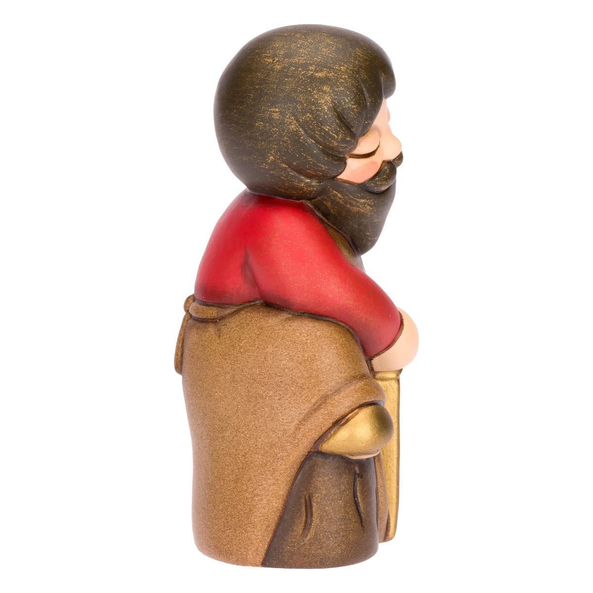 Statuina in ceramica raffigurante un falegname del presepe con folta barba e maglione rosso sotto il grembiule marrone, intento a segare un tronco di legno con una sega dorata. Personaggio dal design classico e curato firmato THUN, ideale per arricchire il presepe o come idea regalo natalizia.