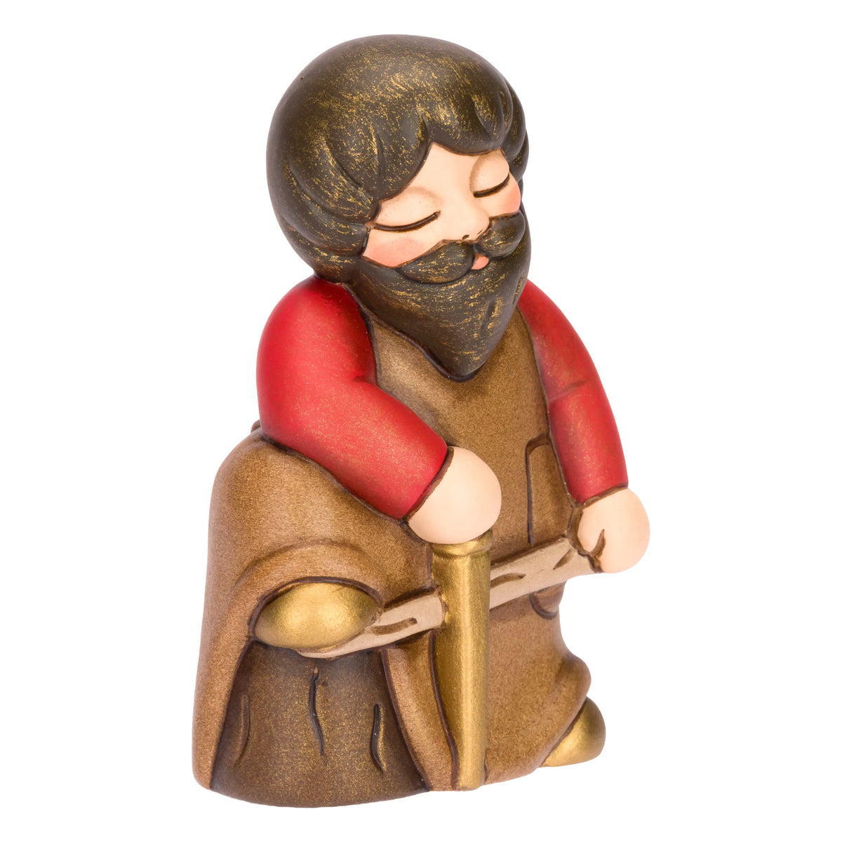 Statuina in ceramica raffigurante un falegname del presepe con folta barba e maglione rosso sotto il grembiule marrone, intento a segare un tronco di legno con una sega dorata. Personaggio dal design classico e curato firmato THUN, ideale per arricchire il presepe o come idea regalo natalizia.