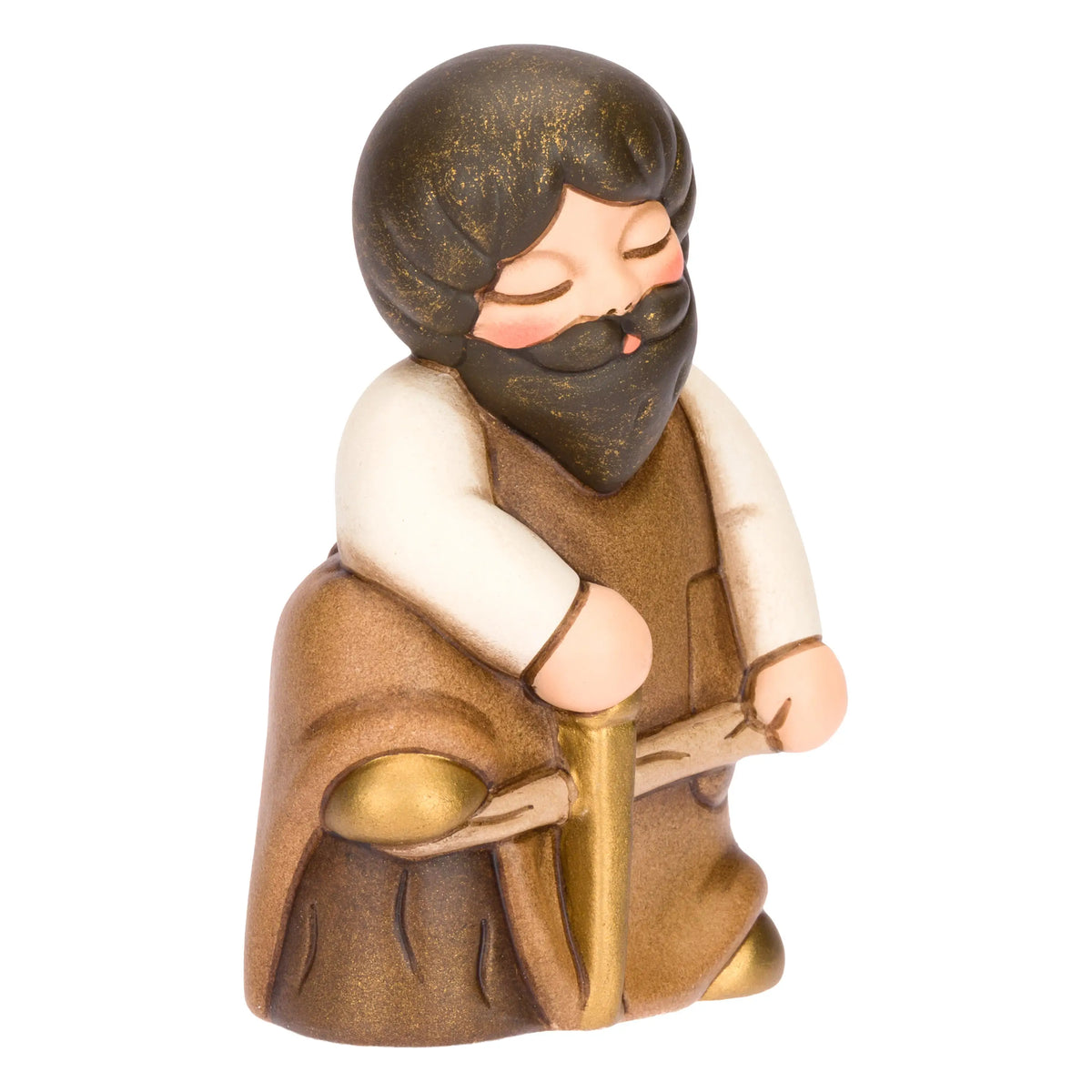 Statuina in ceramica raffigurante un falegname del presepe con folta barba e maglione bianco sotto il grembiule marrone, intento a segare un tronco di legno con una sega dorata. Personaggio dal design classico e curato firmato THUN, ideale per arricchire il presepe o come idea regalo natalizia.