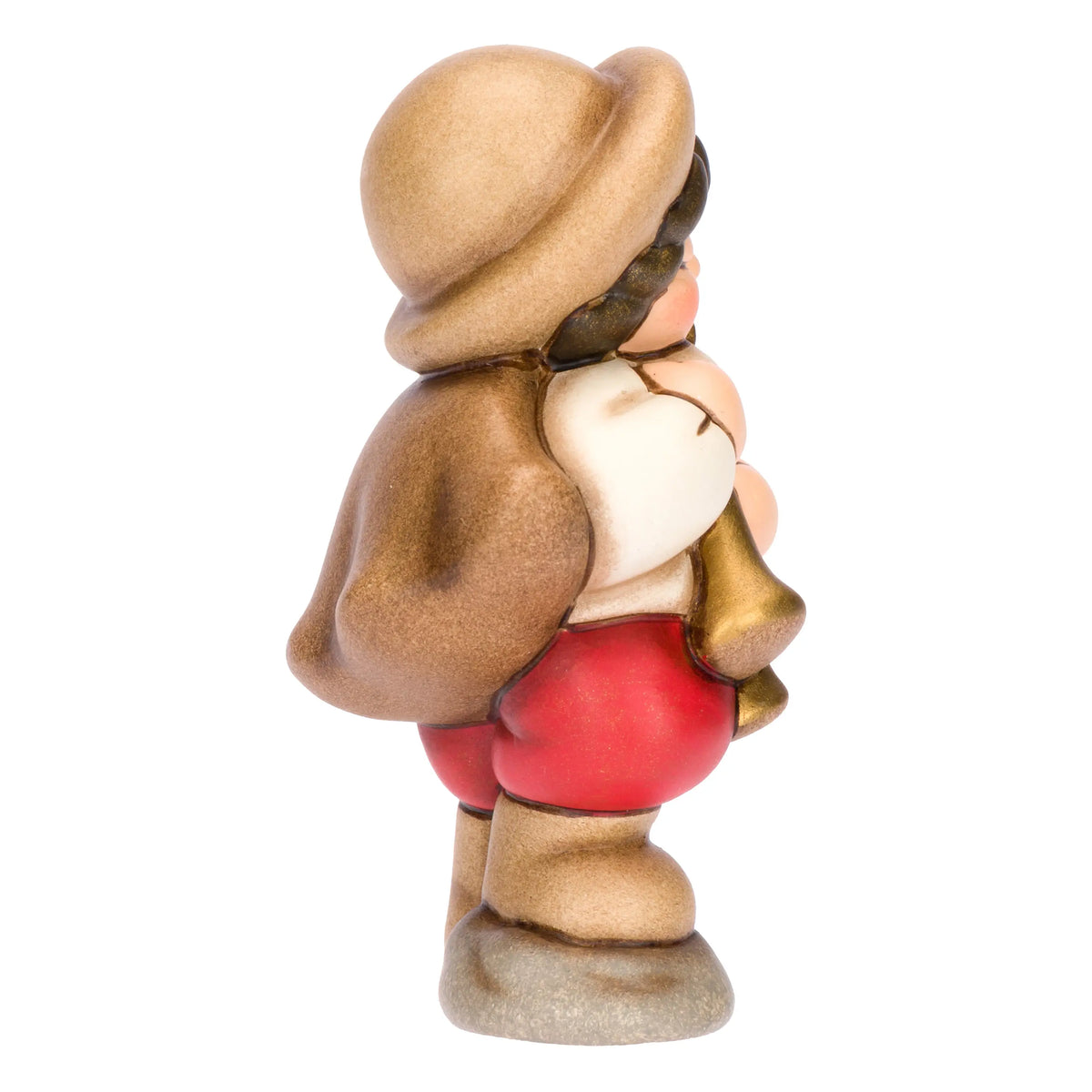 Statuina in ceramica raffigurante un piccolo zampognaro del presepe con cappello marrone e mantello, intento a suonare uno strumento a fiato dorato indossando pantaloncini rossi. Personaggio dal design classico e curato firmato THUN, ideale per arricchire il presepe o come idea regalo natalizia.