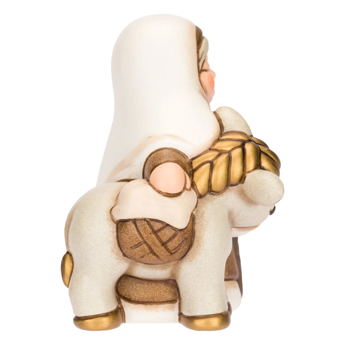 Statuina in ceramica raffigurante una donna del presepe con velo bianco e veste marrone, che accompagna un asinello con basto dorato appoggiando la mano sulla sua testa. Personaggio dal design classico e curato firmato THUN, ideale per arricchire il presepe o come idea regalo natalizia.
